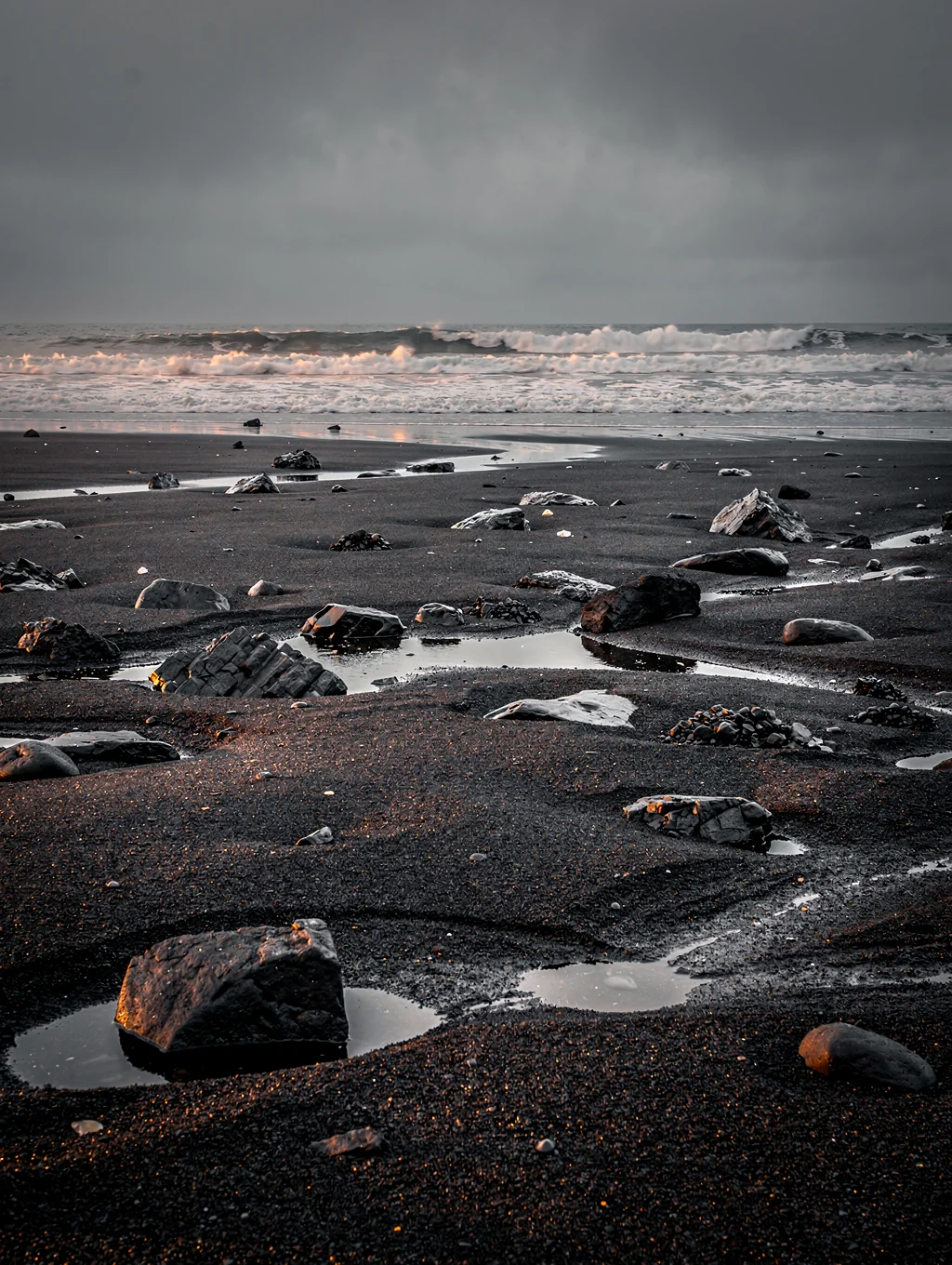 Ice fragments on black volcanic sand beach