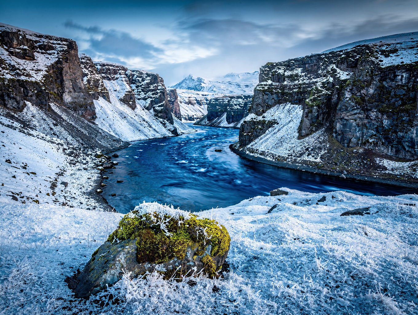 Glacial river system winding through dark volcanic terrain in Iceland